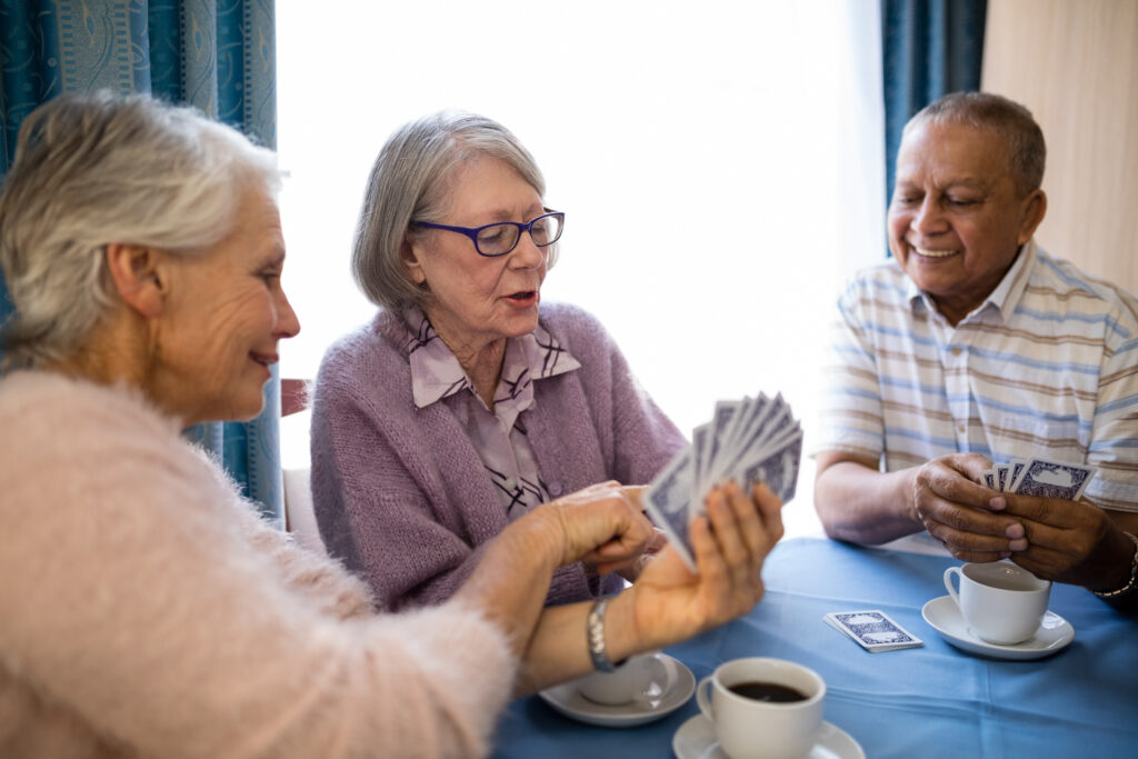 smiling,senior,woman,showing,cards,to,friends,while,playing,at, Stockton, CA senior living consultant